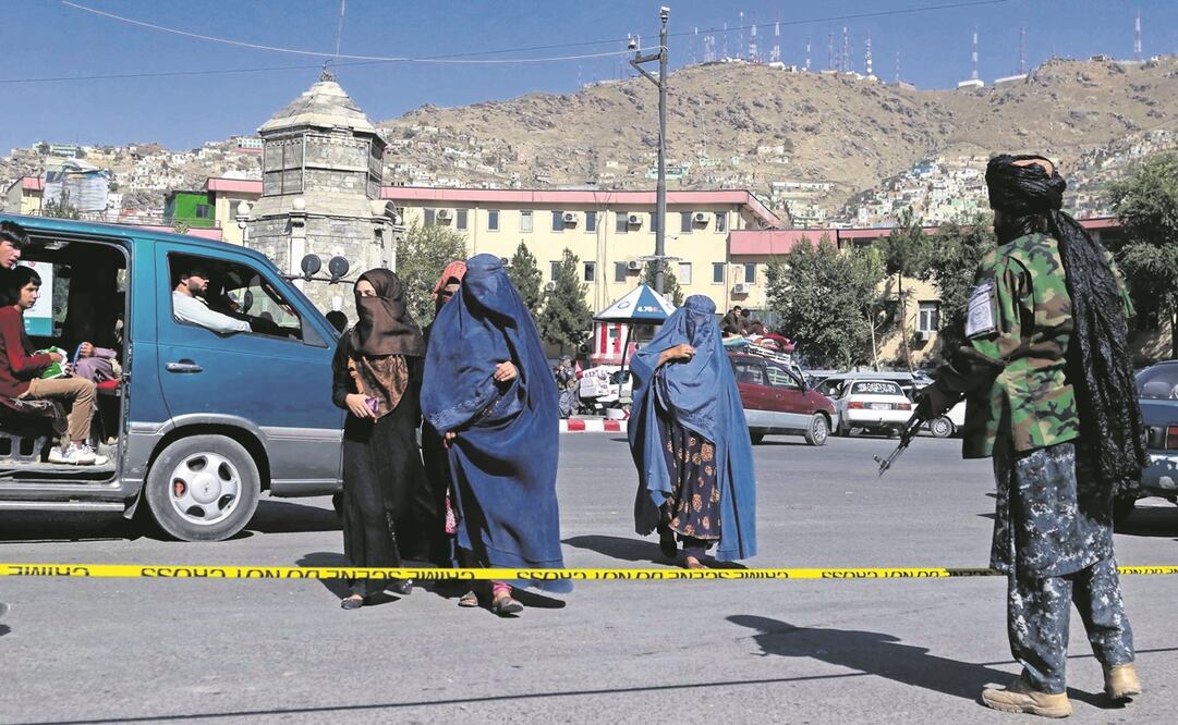 Talibanes observan a afganas mientras patrullan Kandahar. La situación de las mujeres en el país preocupa a la comunidad internacional. Foto: EFE