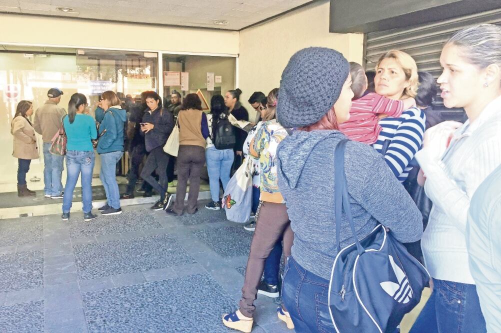 Venezolanos hacen fila en la embajada de su país en Quito para apuntarse en alguno de los vuelos que los regresarán a su país. (DANIELA BRIK. EFE)