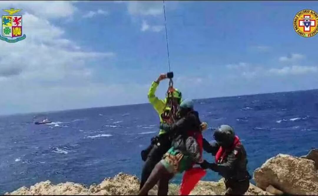 Un migrante varado en un arrecife rocoso en la diminuta isla de Lampedusa es ascendido a un helicóptero de rescate. Foto: AP
