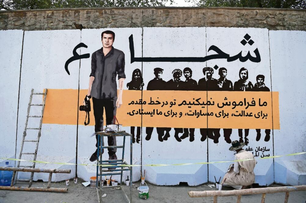 Un artista pinta en Afganistán un mural en memoria del fotógrafo Shah Marai, quien murió cuando cubría un atentado en Kabul . (WAKIL KOHSAR. AFP)