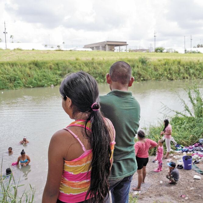 Migrantes se bañan y lavan su ropa en el río Bravo, al otro lado de una carpa en Brownsville donde se realizan audiencias migratorias. REUTERS