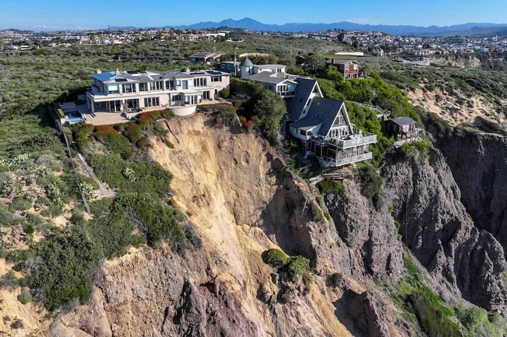 Vista aérea de tres casas grandes en Dana Point están en peligro de caer al océano después de que un acantilado cedió durante el fin de semana después de las fuertes lluvias recientes. FOTO: ESPECIAL
