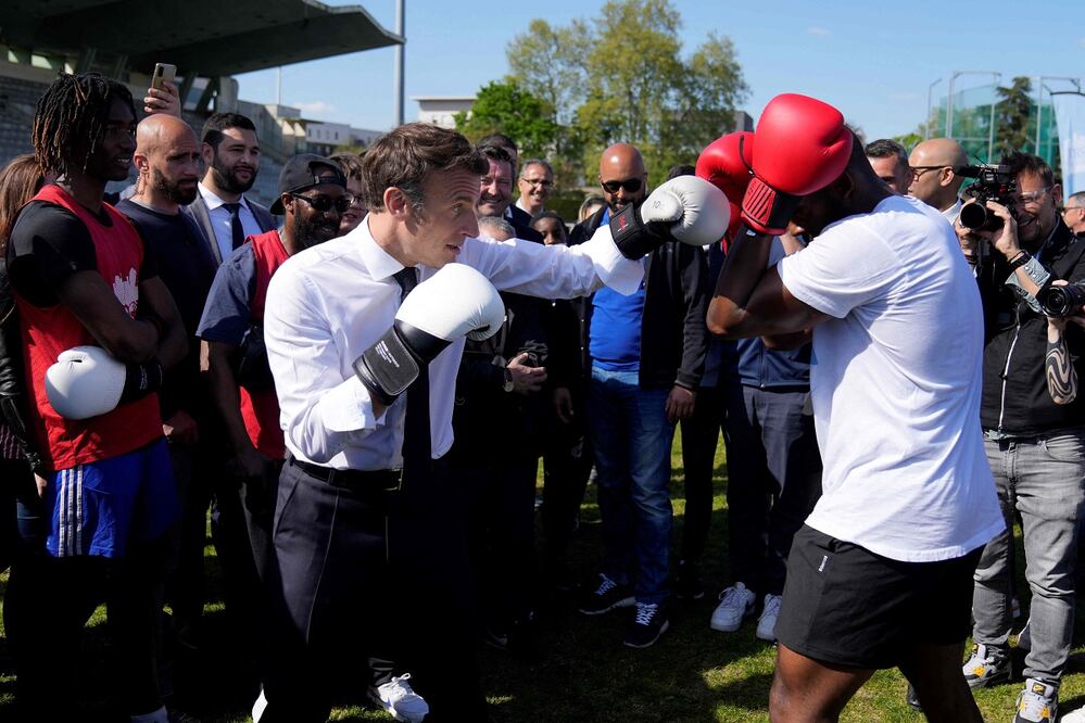 El presidente francés y candidato del partido La Republique en Marche (LREM) a la reelección, Emmanuel Macron, se entrena en boxeo con el boxeador aficionado Jean-Denis Nzaramba, de 23 años, en el estadio Auguste Delaune durante una visita de campaña en Saint-Denis, a las afueras de París. FOTO: AFP