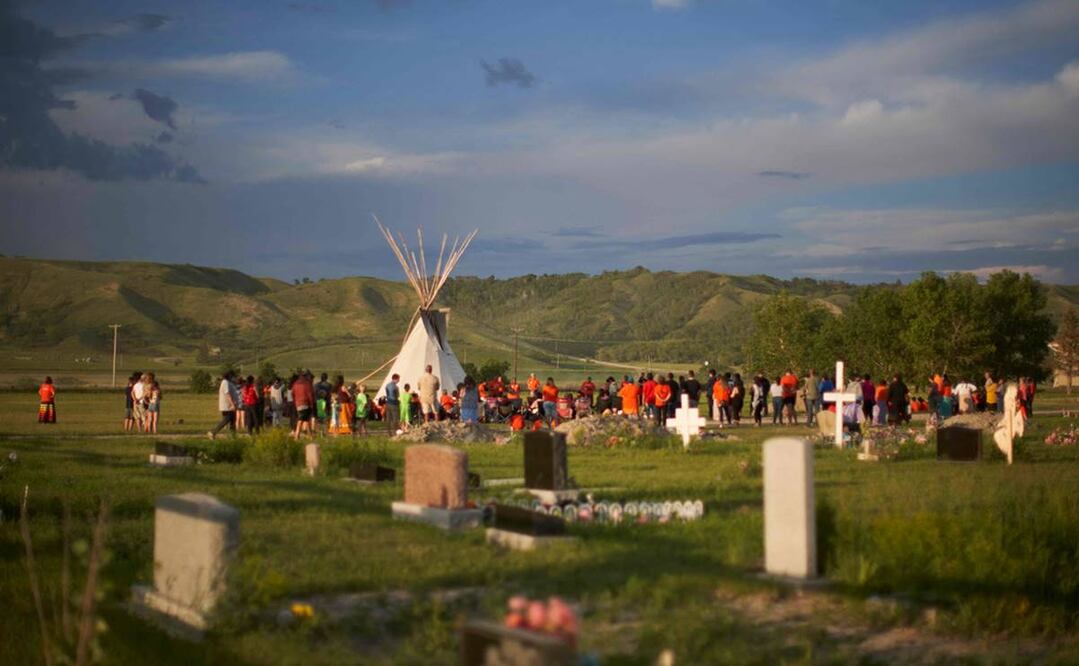 Personas se reúnen en el campo donde se descubrieron restos de menores en Saskatchewan, Canadá, el 26 de junio. Foto: AP