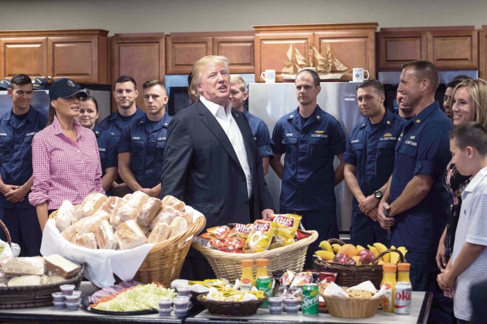 El presidente Donald Trump y su esposa Melania repartieron tortas y papas fritas ayer en una base de la Guardia Costera en Riviera Beach, Florida. (NICHOLAS KAMM. AFP)