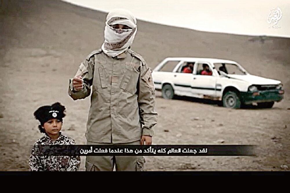 En esta imagen tomada de un video difundido por el Estado Islámico, aparece el niño británico Isa Dare, quien habría hecho detonar una bomba para matar a cuatro "espías" sirios inmovilizados en un coche, en febrero (TOMADA DE VIDEO)