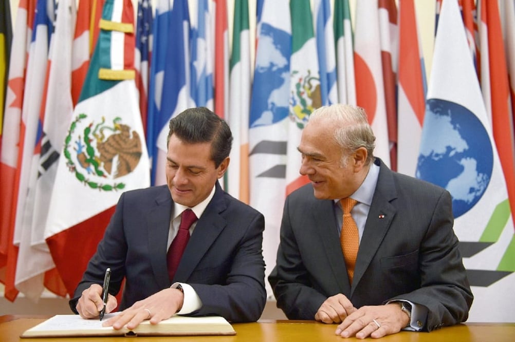 Durante su visita a la Organización para la Cooperación y el Desarrollo Económicos, el presidente Enrique Peña Nieto firmó el Libro de Visitantes Distinguidos, en presencia del secretario general de la organización, José Ángel Gurría.  (PRESIDENCIA)