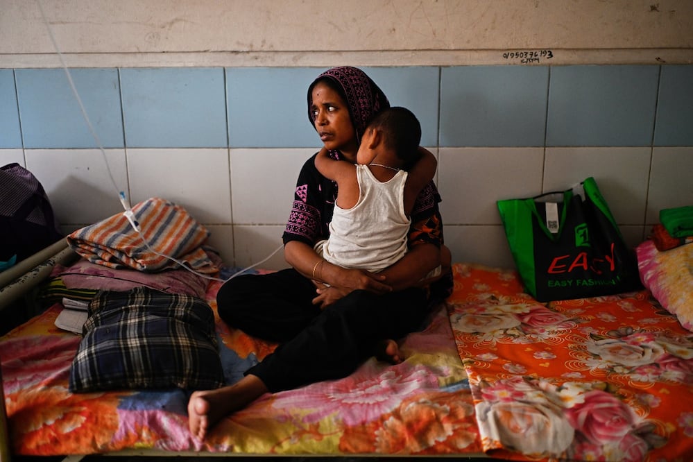 Una mujer cuida de su hijo mientras recibe tratamiento para el sarampión en un hospital de Daca. FOTO: MAHMUD HOSSAIN OPU. AP