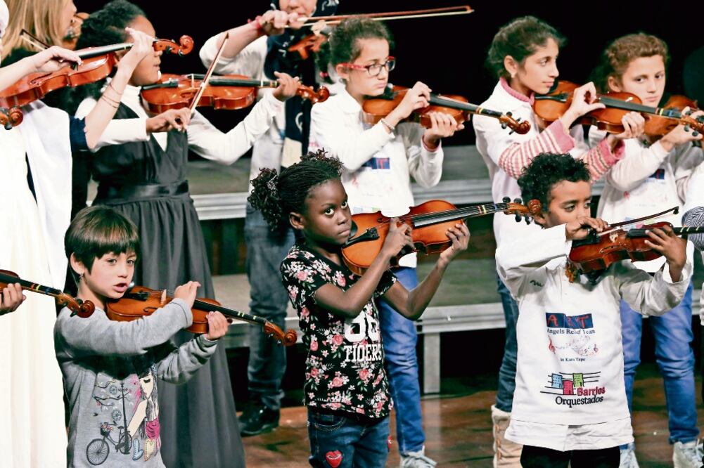 Niños refugiados de Siria, Angola y Afganistán, entre otros, durante un concierto en la isla griega de Lesbos, donde la organización ART les enseña a tocar instrumentos (LEFTERIS PITARAKIS. AP)
