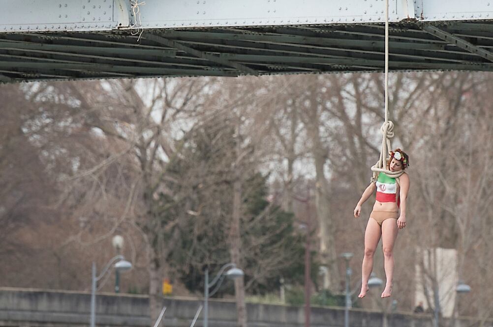 Sarah Constantin, activista de Femen, se colgó simbólicamente desde un puente, en París, para hacer alusión al gran número de ejecuciones que se realizan en Irán (ZACHARIE SCHEURER. AP)