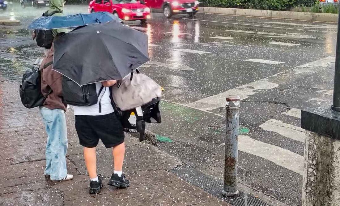 Fuerte lluvia con ligero granizo sorprende a capitalinos que transitan por paseo de la Reforma a la altura de la Estela de Luz. Foto: Luis Camacho | El Universal