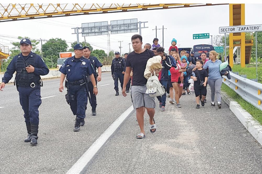 Policías estatales caminan junto a los centroamericanos que pretendían huir de la estación migratoria de Tenosique. Foto/ LUMA LÓPEZ. EL UNIVERSAL