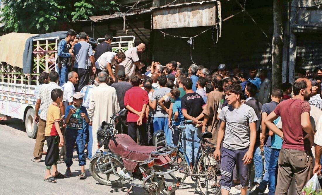 Civiles de la ciudad de Aleppo, que se encuentra asediada por las fuerzas gubernamentales sirias apoyadas por Rusia (ABDALRHMAN ISMAIL. REUTERS)