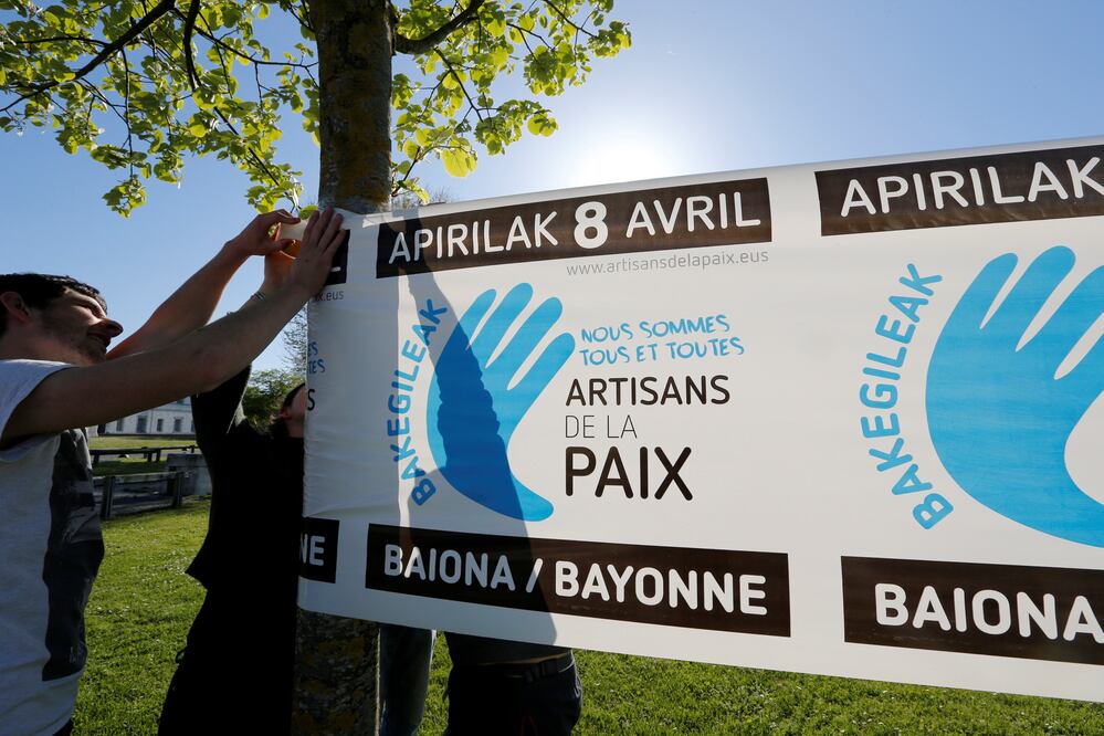Jóvenes con una pancarta que hace alusión al proceso de desarme de ETA. (Reuters)