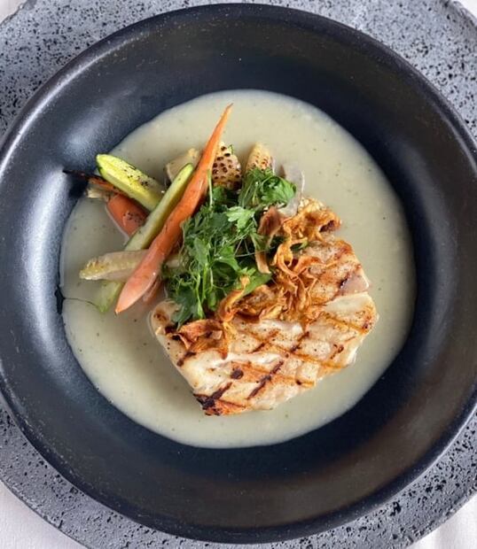 Pesca al carbón en salsa de limón con verduras del huerto