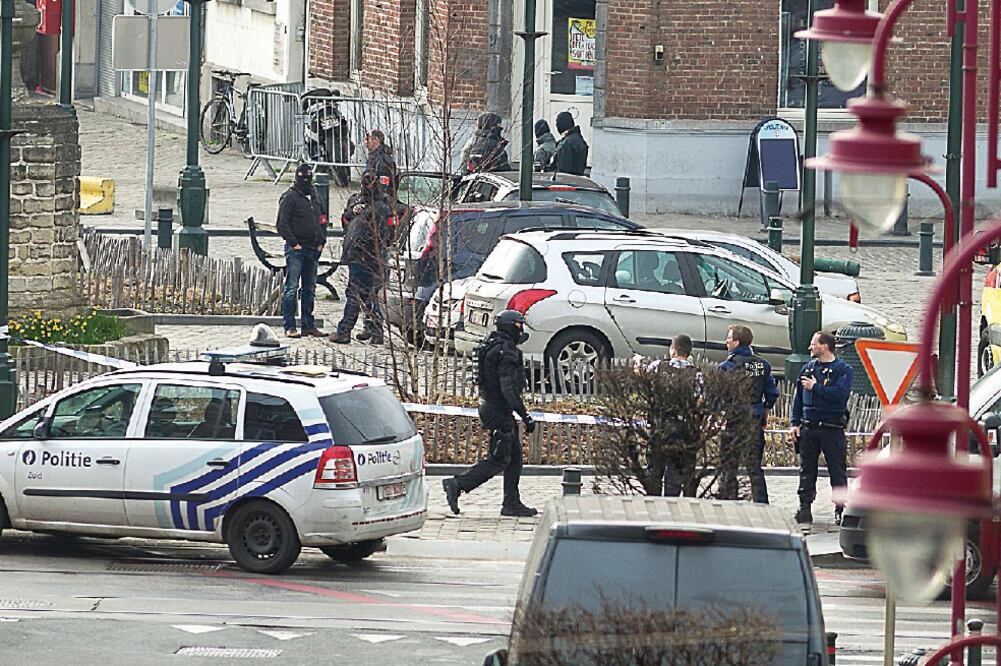 La policía asegura una zona en Vorst, Bruselas, donde realizó ayer un operativo antiterrorista relacionado con los ataques del año pasado en París. Las autoridades informaron que el despliegue continuaría (THIERRY MONASSE. AP)