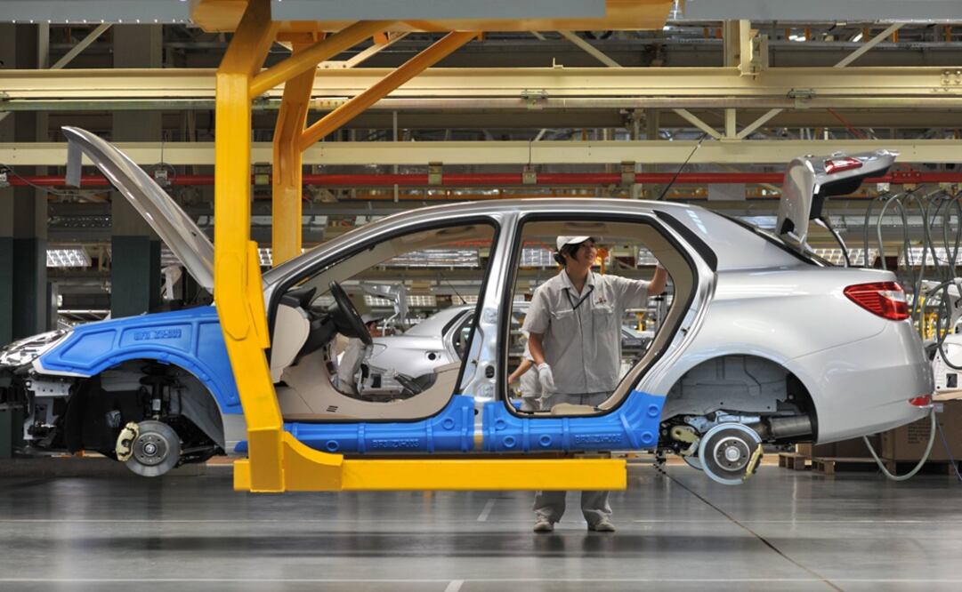 An employee works on a car assembly line – Photo: File photo/AP