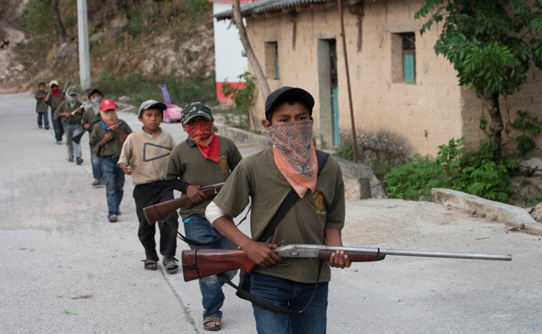 Children walk in a single file, holding toy and real guns, as they demonstrate newly learnt skills from military-style weapons training – Photo: Alexandre Meneghini/REUTERS