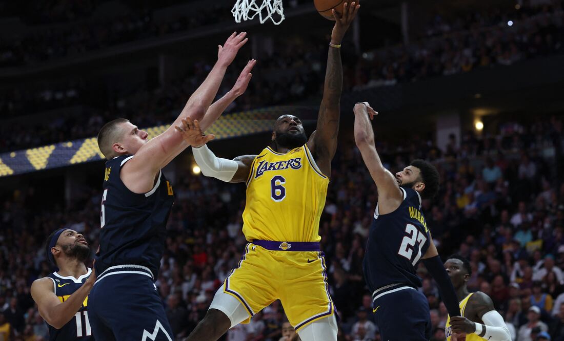 LeBron James se levanta entre Nikola Jokic y Jamal Murray / Foto: AFP