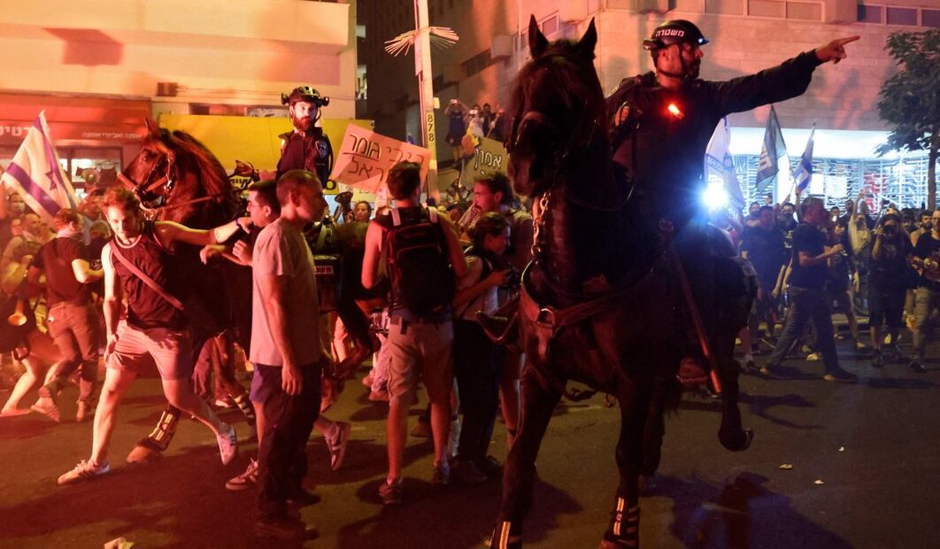 Familiares y partidarios de israelíes tomados como rehenes por militantes palestinos en Gaza en los ataques del 7 de octubre encienden bengalas y sostienen retratos de los tomados durante una protesta pidiendo su liberación. Foto: AFP