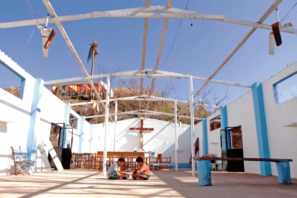 Dos niños juegan en la iglesia de la Inmaculada Concepción, en Arroyo Seco, Jalisco, que perdió el techo y sufrió desperfectos tras el paso del ciclón (RAMÓN ROMERO. EL UNIVERSAL)