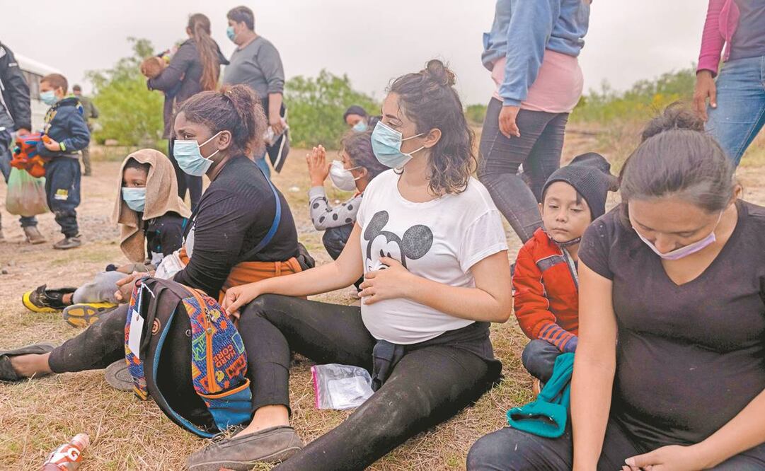 Mujeres embarazadas con sus familias esperan para abordar un autobús de la Agencia de Aduanas y Protección Fronteriza de EU que las trasladará a un centro de procesamiento de migrantes, en La Joya, Texas, en la frontera con México. Foto: John Moore/ AFP.