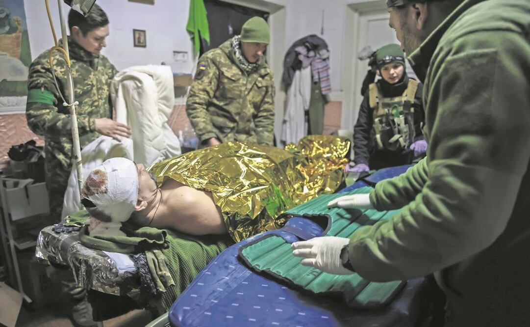 Médicos dan primeros auxilios a un soldado ucraniano herido cerca de Bakhmut, en la región de Donetsk. Foto: Yevhen Titov/AP