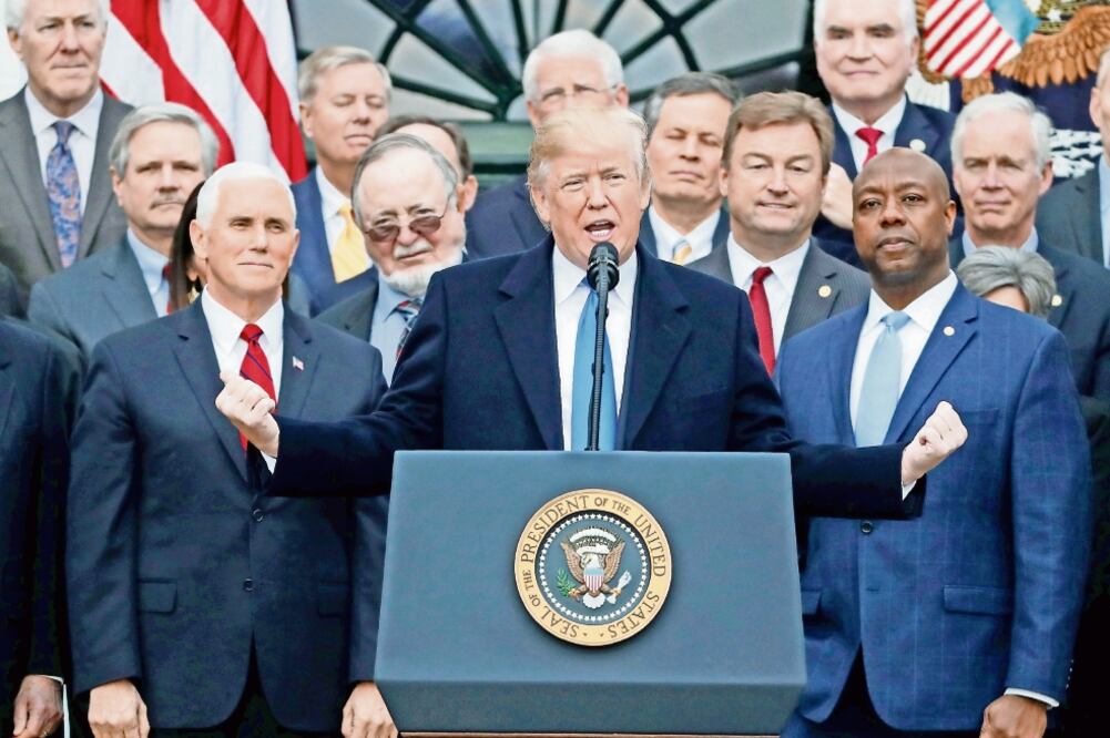 El presidente estadounidense Donald Trump posa con legisladores republicanos que aprobaron la reforma tributaria en EU (JONATHAN ERNST. REUTERS)