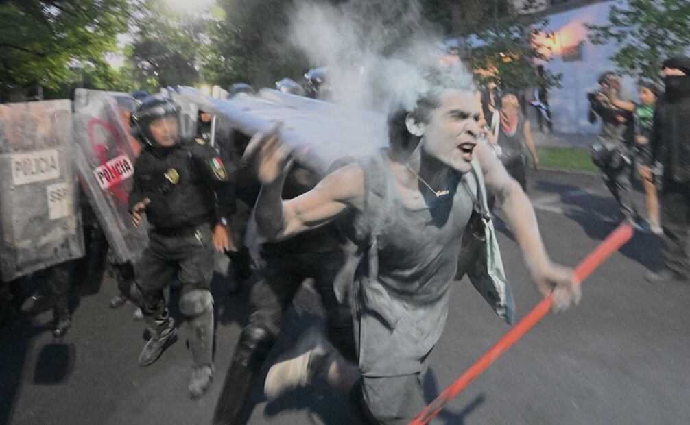 Con pintura roja, los manifestantes pintaron las vallas policiacas, por lo que respondieron rociando el contenido de extintores. Foto: AFP