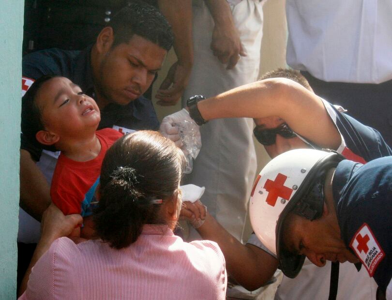 Socorristas de Cruz Roja de México evacúan a un niño de la guardería que se incendio y que provocó la muerte de al menos 29 bebés, de entre tres meses y dos años, Foto: Periódico El Imparcial