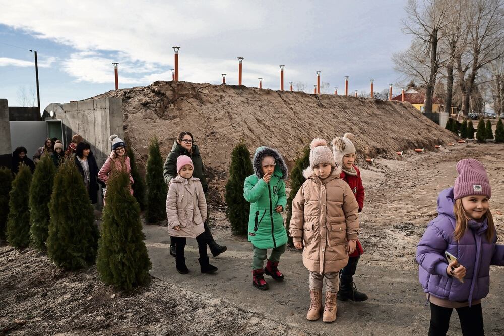 Niños abandonan un refugio antibombas durante ensayos de seguridad organizados por la policía ucraniana en la localidad de Ozera, ante la posibilidad de un ataque ruso. Foto: EFE