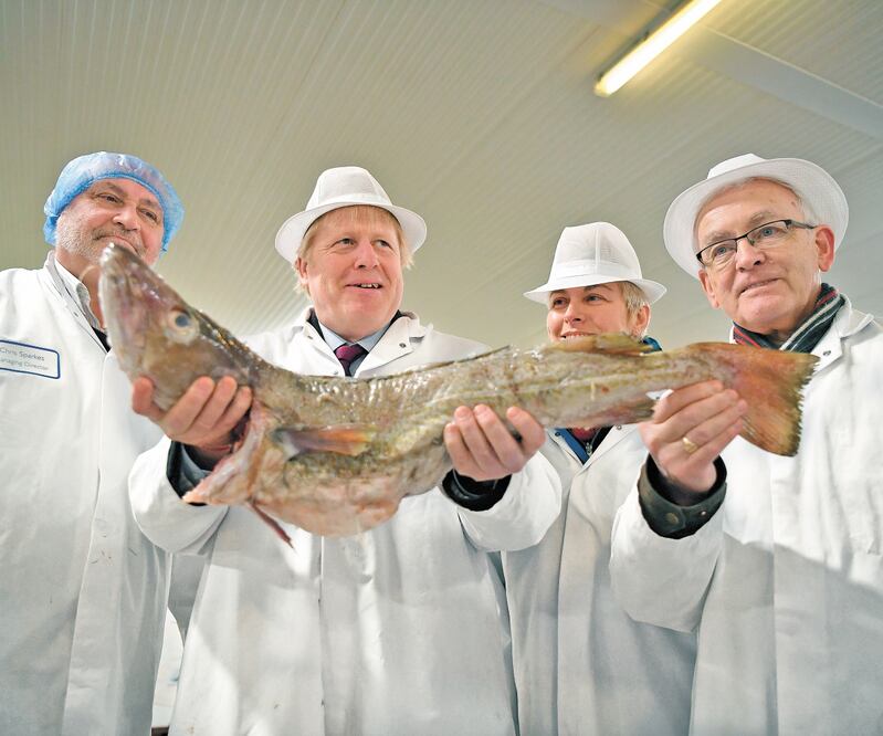 El primer ministro británico, Boris Johnson (segundo de izq. a der.), visitó un mercado de pescado en Grimsby, en el noreste de Inglaterra. BEN STANSALL. AP