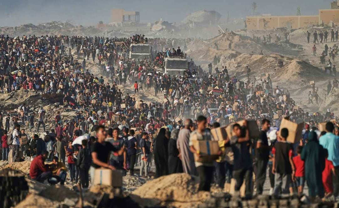 Personas cargan sacos y cajas con alimentos y ayuda humanitaria descargados de un convoy del Programa Mundial de Alimentos que se dirigía a la Ciudad de Gaza, el 16 de junio de 2025, en el norte de la Franja de Gaza. Foto: AP