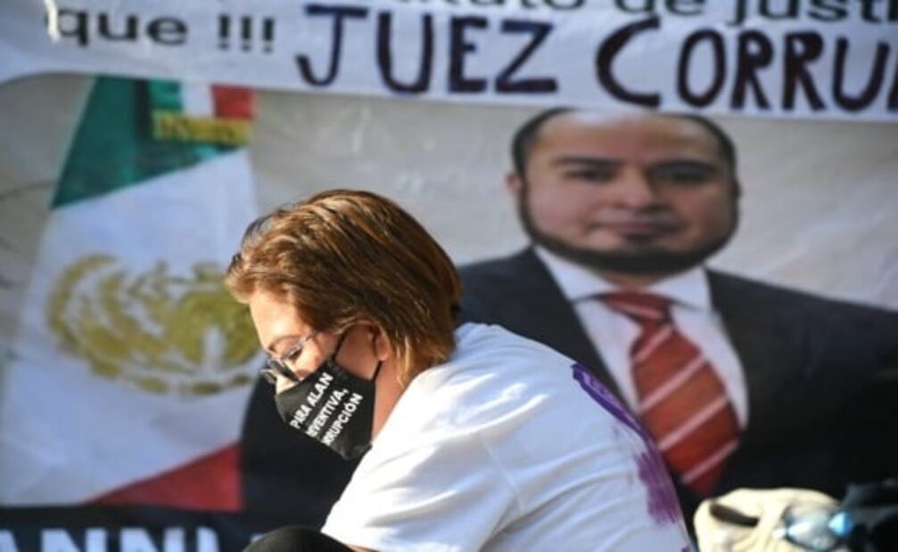 Mujer envuelta en bandera frente a Palacio Nacional exige justicia para su hijo asesinado