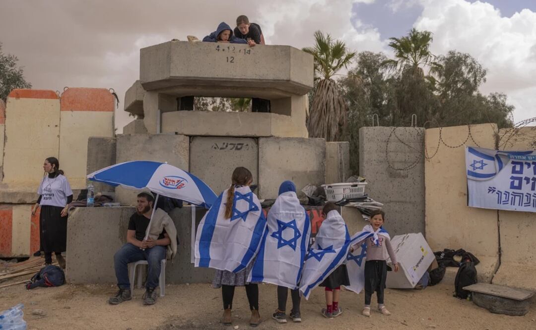 Varias personas esperan junto al paso fronterizo israelí de Nitzana, en la frontera con Egipto, el 27 de febrero de 2024 en protesta por la entrada de ayuda humanitaria a Gaza sin que se haya liberado a todos los rehenes capturados por Hamas. Foto: AP