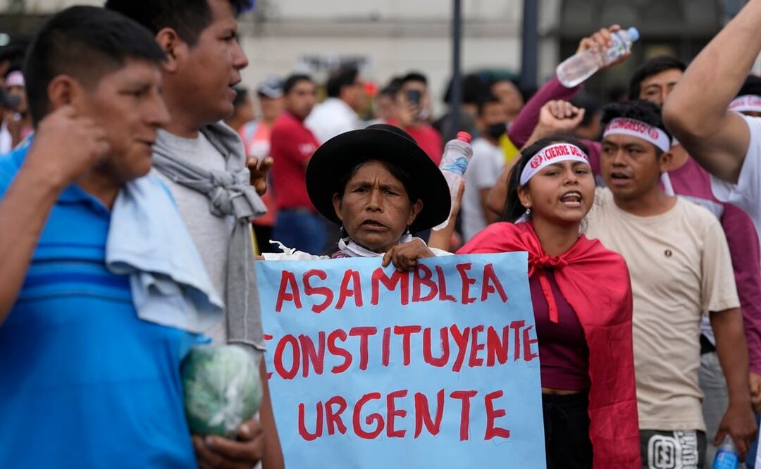 Una mujer sostiene un cartel que pide convocar a una asamblea constituyente durante una marcha de manifestantes de oposición. Foto: AP
