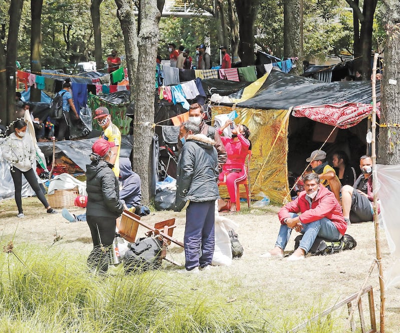 Venezolanos en un campamento creado hace 13 días, en la autopista norte, en Bogotá, Colombia. La pandemia obligó a los inmigrantes a aceptar trabajos en condiciones de esclavitud laboral. Foto: MAURICIO DUEÑAS. EFE