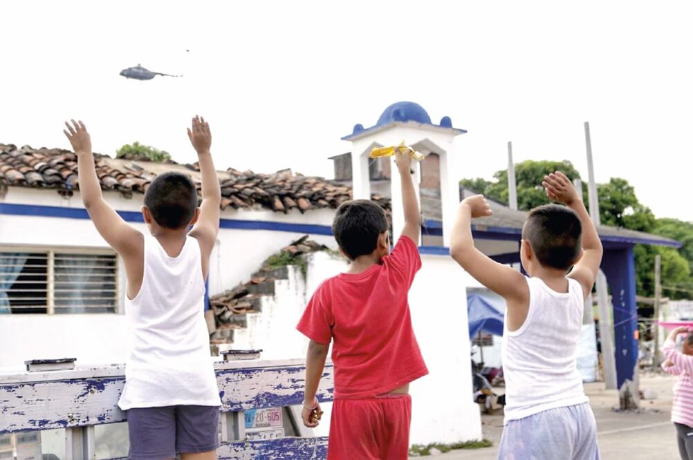 Luego del terremoto, un helicóptero sobrevuela el municipio para levantar el reporte preliminar de daños; los niños tratan de llamar su atención. (ROSELIA CHACA. EL UNIVERSAL)