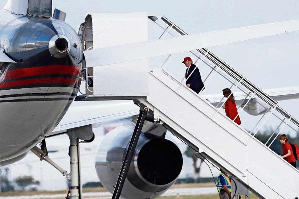 Donald Trump, ganador de los comicios del pasado día 8, con Melania, su esposa, y su hijo Barron, al subir a su avión en el aeropuerto de Palm Beach (CAROLYN KASTER. AP)
