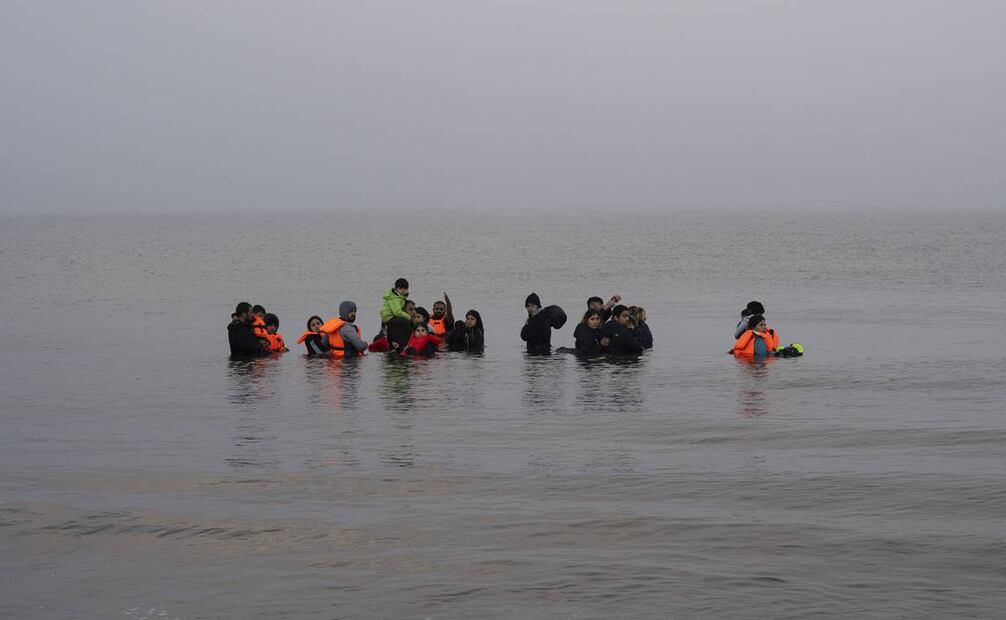 Un grupo de inmigrantes kurdos de Irán e Irak que fracasaron en su intento de llegar al Reino Unido en barco después de ser descubiertos por la policía, en la playa de Ambleteuse, al norte de Francia. Foto: AP