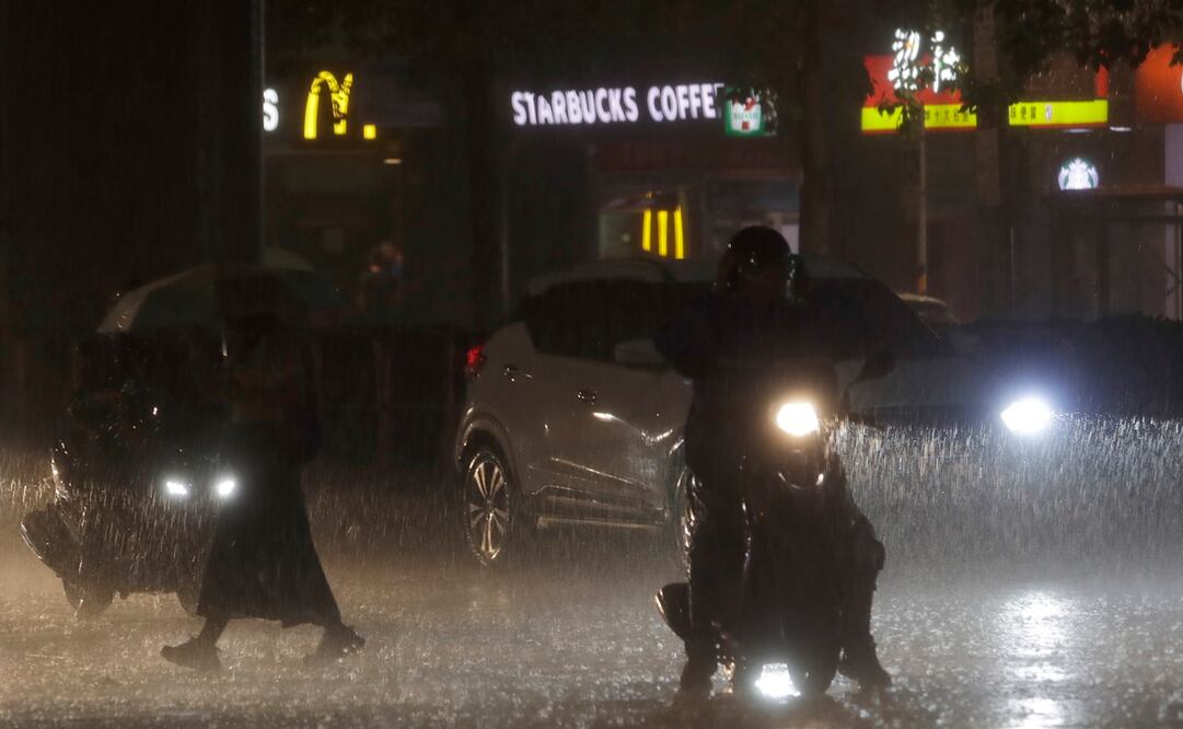 La gente camina y conduce bajo una fuerte lluvia mientras el tifón Haikui se acerca al país, en Taipéi, Taiwán. Foto: AP