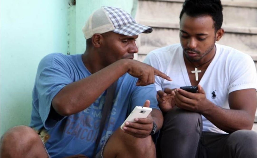 Dozens of people, many of them young, sat on stairs and stoops tapping away at smartphones, tablets and laptops . (Photo: EFE )