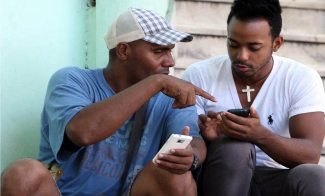 Dozens of people, many of them young, sat on stairs and stoops tapping away at smartphones, tablets and laptops . (Photo: EFE )