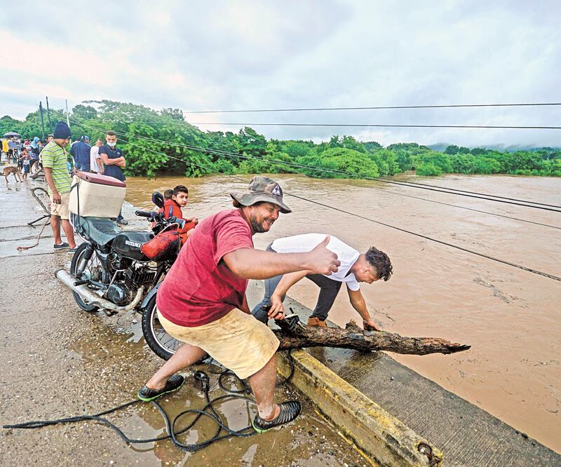 Personas recolectaron madera tras la llegada del huracán Eta , en Santa Rita, departamento de Yoro, al norte de Tegucigalpa. Hasta el momento una niña murió tras el impacto del fenómeno meteorológico en Honduras. ORLANDO SIERRA. AFP