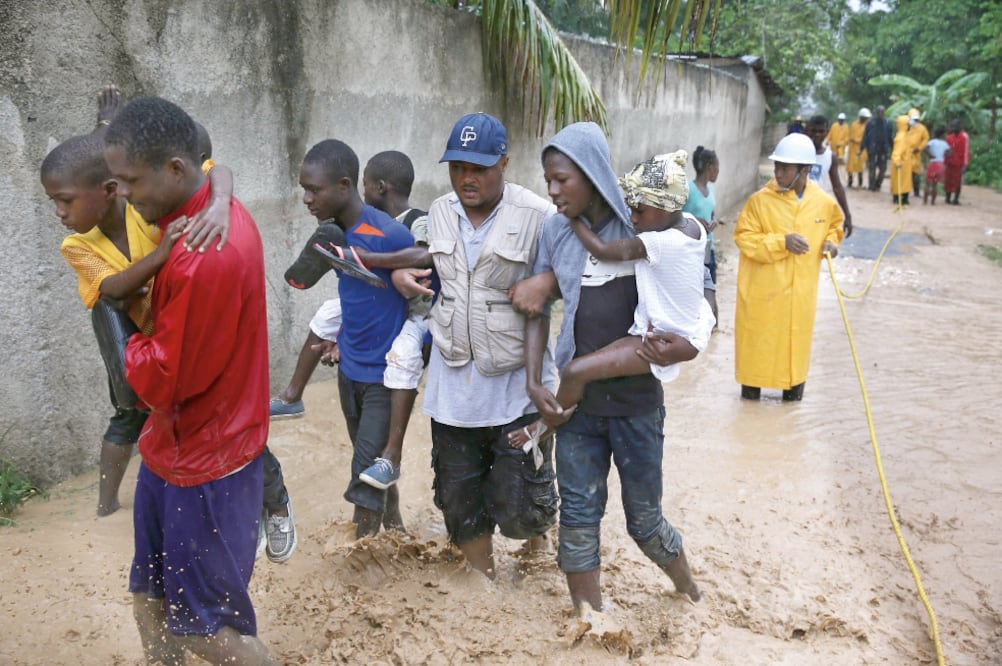 Haitianos fueron rescatados ayer en Font Parisienne, tras el paso del huracán Matthew . El gobierno y la Cruz Roja movilizaron en el país a miles de socorristas voluntarios (ORLANDO BARROA. EFE)