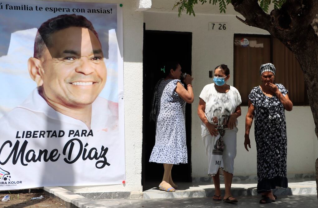 Varias personas, al salir de la casa familiar del futbolista colombiano Luis Díaz, de donde cuelga un gran cartel con la imagen de su padre, Luis Manuel Díaz, secuestrado el pasado sábado, en Barrancas, departamento de La Guajira. Foto: EFE