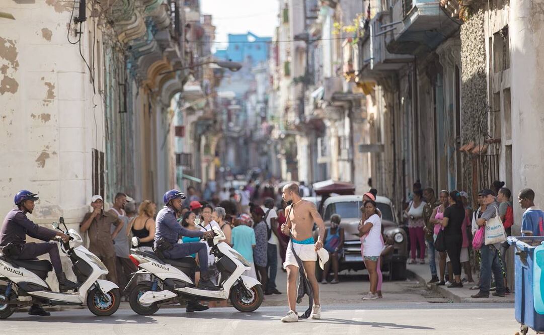 Cubanos en medio del tránsito, en una calle de La Habana. Foto: Yander Zamora/ EFE