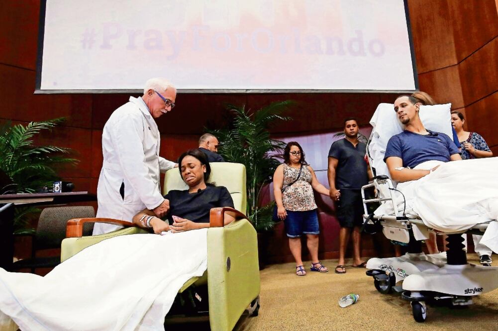 Un médico consuela a Patience Carter, una de las sobrevivientes del ataque en el bar Pulse, tras presentar su testimonio a la prensa desde el Centro Médico Regional de Orlando, donde está internada (JIM YOUNG. REUTERS)