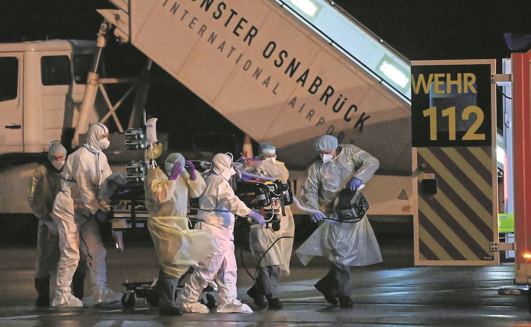 Personal sanitario traslada a una persona contagiada con Covid-19 en el Aeropuerto de Münster/Osnabrück, Alemania. Foto: Ina Fassbender/ AFP.