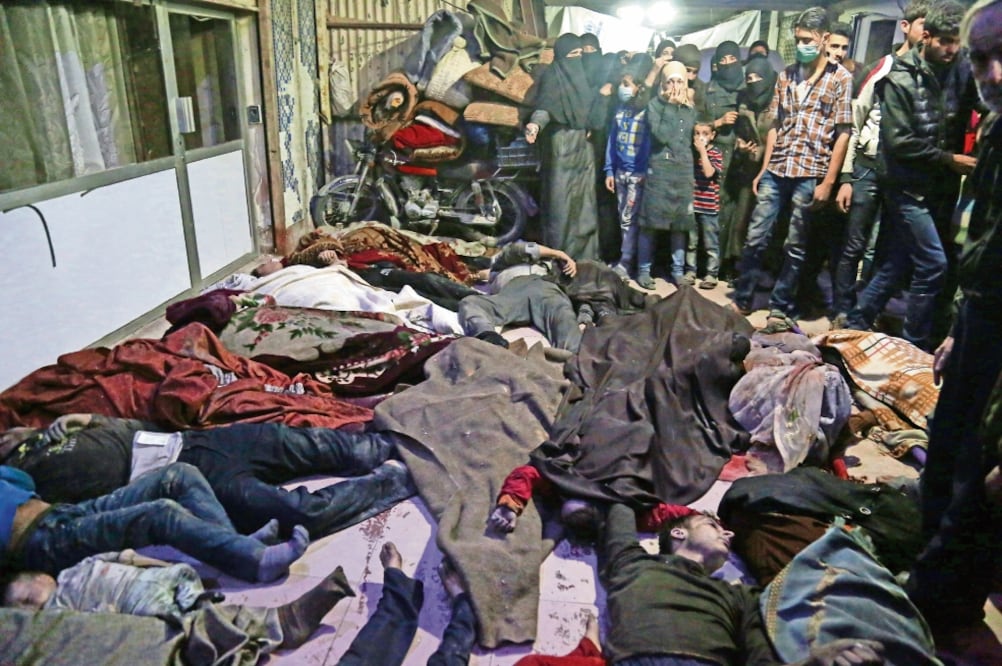 Esta imagen muestra los cuerpos de algunas de las víctimas mortales a causa del ataque registrado la noche del sábado en la población de Duma, en Guta Oriental, Siria. (EMAD ALDIN. EFE)